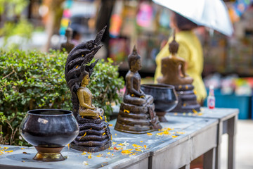 The background of a hand that uses a glass of water, pouring water into the Buddha image, has blurred currents flowing, on the occasion of Songkran Day, New Year and various festivals.