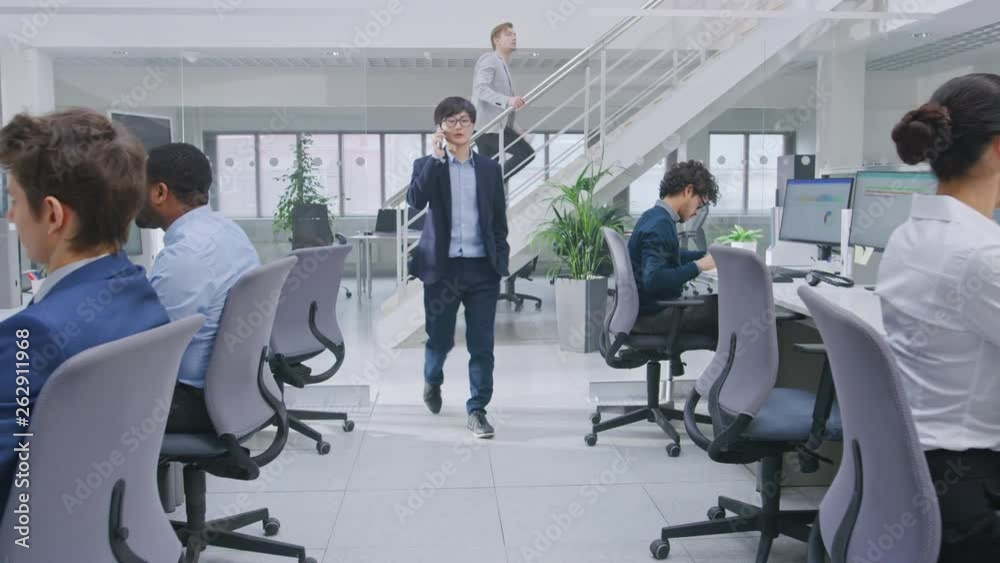 Aufkleber in modern office: diverse team of managers and specialists work on computer, have discussion with co