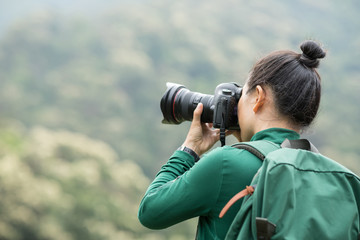 Obraz premium woman photographer taking photo on spring forest mountain
