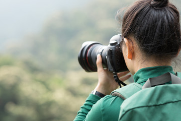 woman photographer taking photo on spring forest mountain