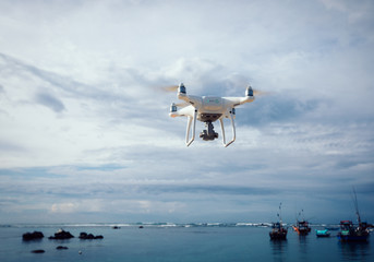 Drone flying over the sea under cloudy sky