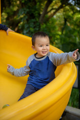Fototapeta na wymiar Asian kid on slide
