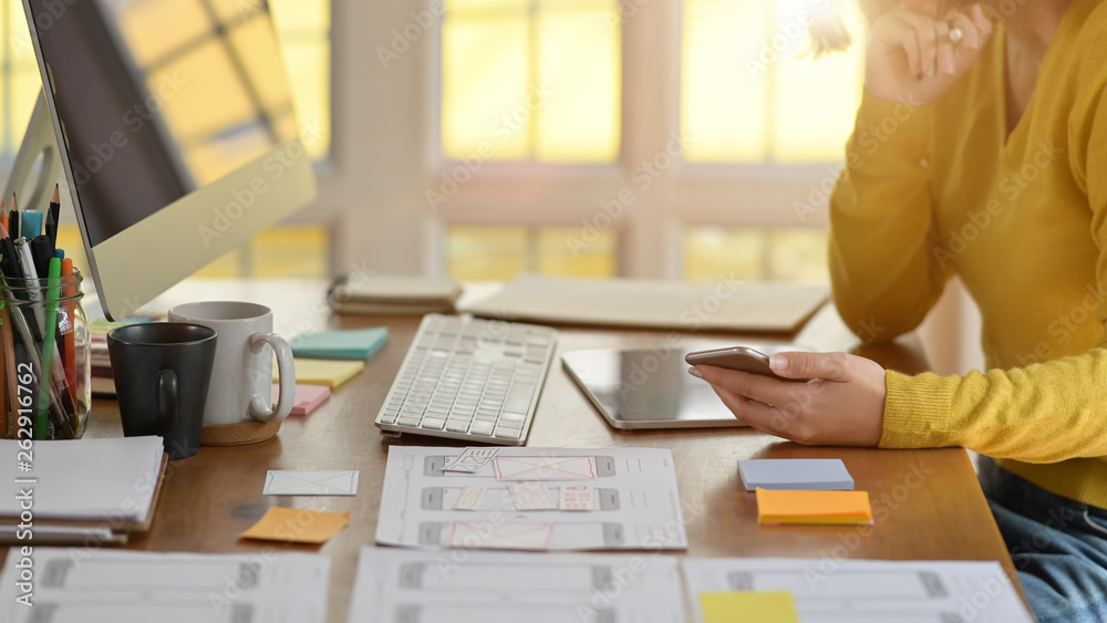 Wall mural ux designer designing web on tablet for smartphone layout in office