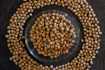 chickpeas in the form of a circle in a plate on a dark background of horizontal orientation