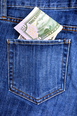 Paper banknotes of American dollars lie on the blue worn jeans.