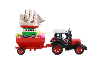 Red tractor toy carry small car and boat isolated on white background