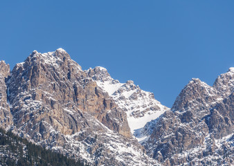 view of rocky mountains on a sunny spring day with clear blue sky.
