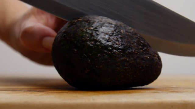 Person cutting open an avocado.