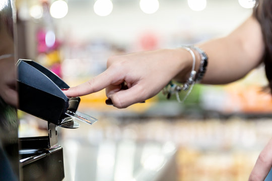 Woman hand using payment terminal in shop. Paying with credit or debit card, credit card reader. Finance and banking concept. Buy & Sell service and product.