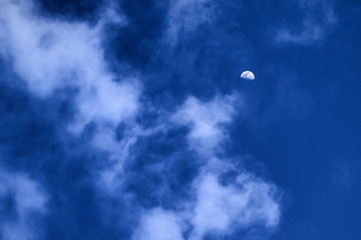 The Moon in the Daytime Blue Sky