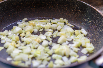 Fried onion in oil in a frying pan.