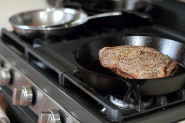 Tri-tip roast in a cast iron pan resting on the oven.