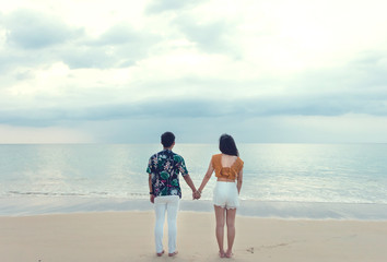 Fototapeta na wymiar Couple in love see sunset at the beach