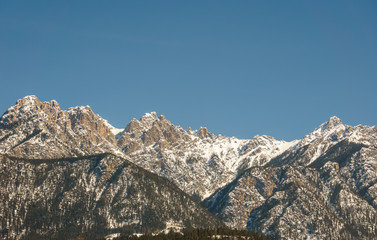 view of rocky mountains on a sunny spring day with clear blue sky.
