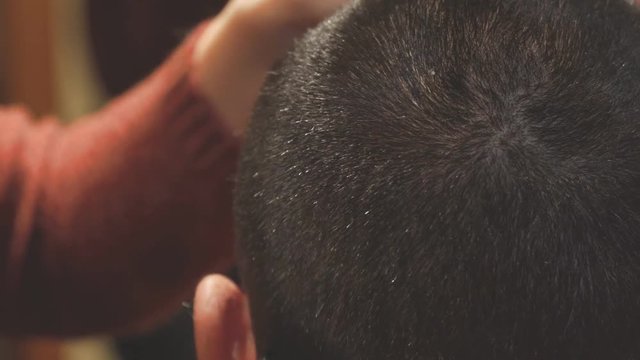 Woman Hairdresser cuts man's hair with electric clipper trimmer. Selective focus