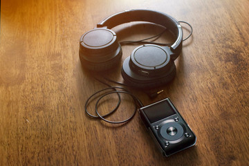 Mp3 music player with headphone on wooden table