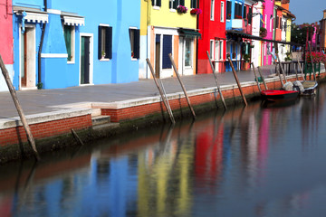 Fototapeta na wymiar Navigable canal on Burano Island near Venice in Italy and the fa