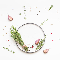 Empty plate with greens herbs and spices around