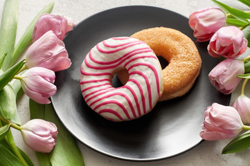 Sugar and Striped-glazed donuts with tulips on black plate