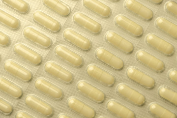 many pills laid out in rows, for background, low contrast, haze