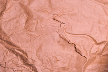 Texture of crumpled recycled wrapping paper. Orange colors.