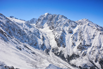 Fototapeta na wymiar Winter snow covered mountain peaks. Tourists Ala-Archa National Park in Kyrgyzstan.