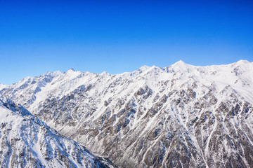 Winter snow covered mountain peaks. Tourists Ala-Archa National Park in Kyrgyzstan.