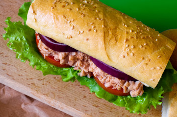 Tuna sandwich on wooden tray. Selective focus. Green background.