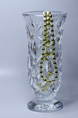 Close-up view of a beautiful modern lead crystal glass vase adorned with golden beads