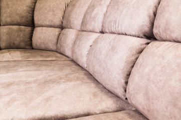 Close-up of an expensive soft textile sofa of beige color with brown shades. Interior Background