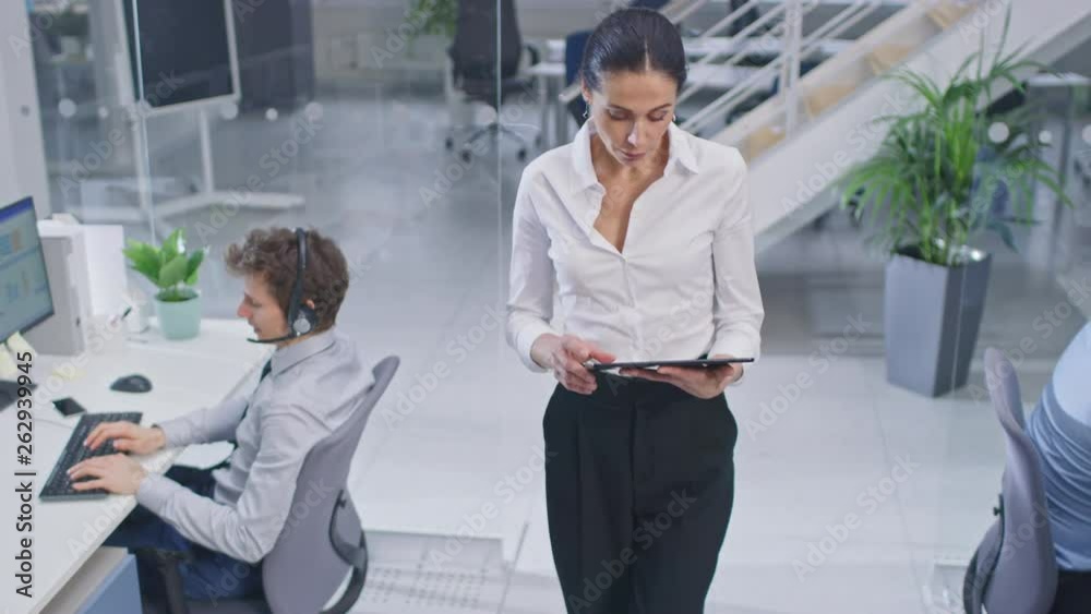 Poster beautiful female manager is walking pass her customer service operator colleagues and supervise thei