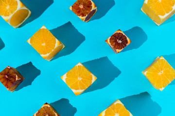 Flatlay of cubes cut out of various oranges on blue