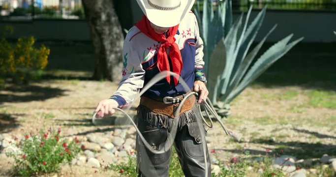 American cowboy throws a lasso rope at the ranch before rodeo, 4k
