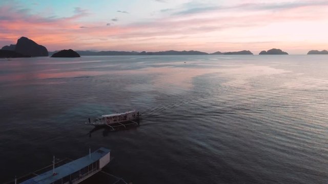 Aerial view of boats and yachts in the tropical bay on the sunset. El Nido, Palawan, Philippines. Marine tropical sunset over the sea. Travel concept.