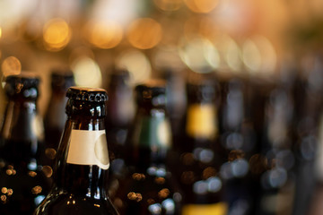 Bottles of beer stand in the background of the blur pub in the evening
