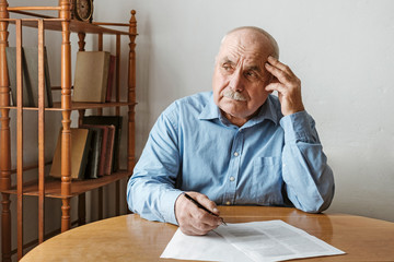 Worried elderly man completing a form