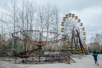 Abandoned carousel and abandoned ferris at an amusement park in the center of the city of Pripyat,...