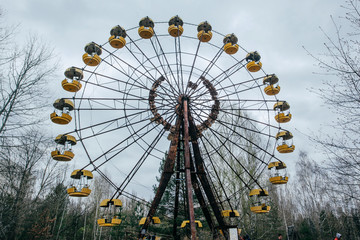 Abandoned carousel and abandoned ferris at an amusement park in the center of the city of Pripyat,...