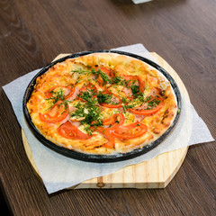 fast food, italian kitchen and eating concept - close up of homemade pizza on wooden table