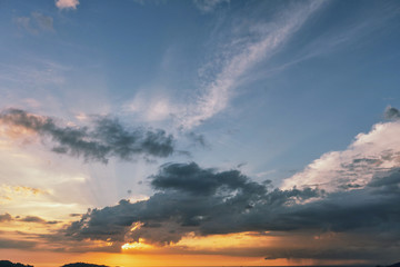 blue cloudy sky and sun in sunset colors