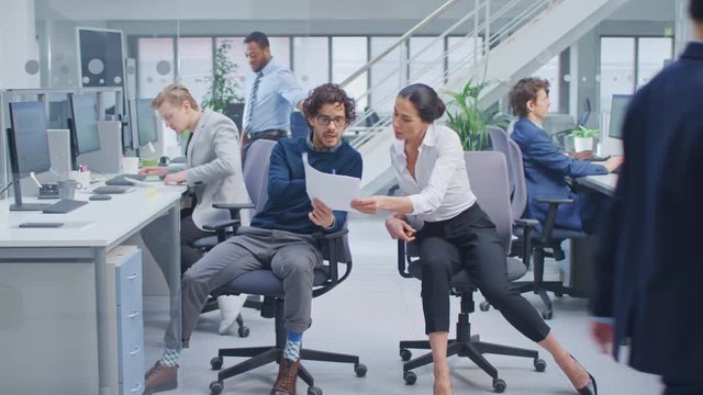 Diverse Team of Business Managers and Specialists Work on Desktop Computers with Two Rows of Tables Side by Side. Young and Motivated Business people in Modern Open Office.