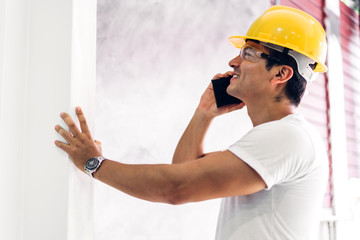 Young construction engineer in a yellow helmet working and  looking job for planning project at building home site