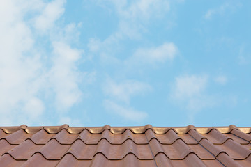 Roof house with tiled roof on blue sky.