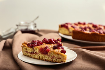 Plate with piece of tasty cranberry pie on table