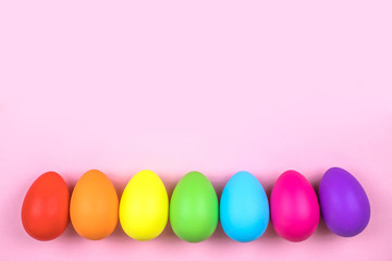 Colored Easter eggs on pink background. Flatlay.