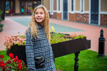 Little fashionable girl in warm clothes walk outdoor, Autumn - Winter season, holidays and children concept. Sweet girl at European street  