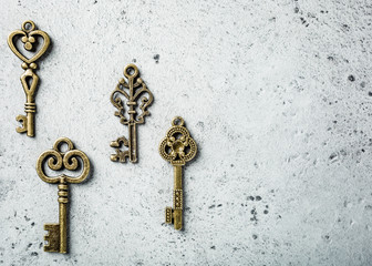 Overhead shoot of many different old keys on old gray concrete background. Concept with copy space.