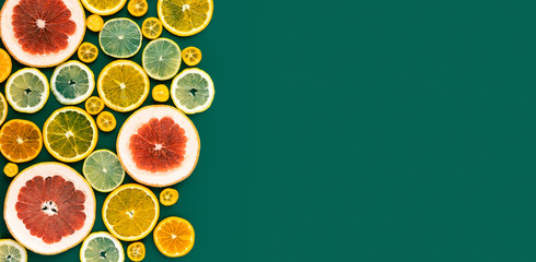 Juicy fresh bright summer green vertical background with citrus fruits, flat lay. Sliced mixed...