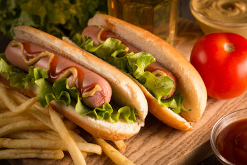 Photo of barbecue grilled hot dog with yellow mustard and ketchup on wooden background. Hot dog...