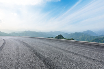 Asphalt race track ground and mountain with clouds background